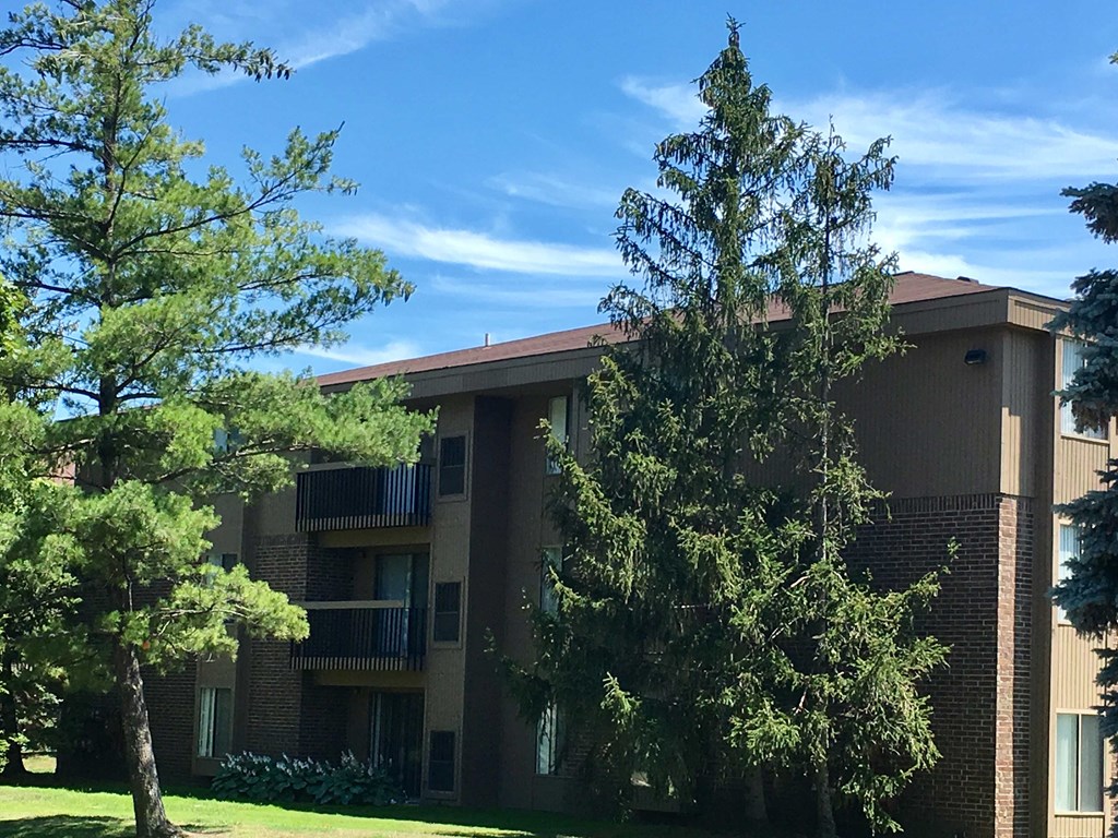 an apartment building with trees in front of it