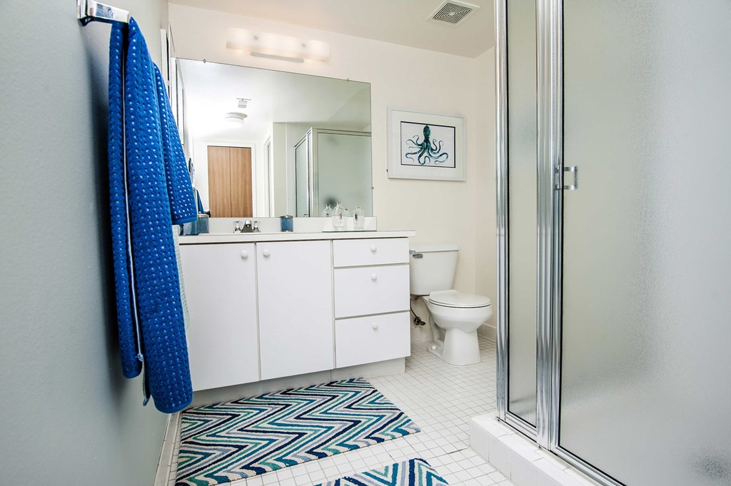a white bathroom with a shower toilet and sink