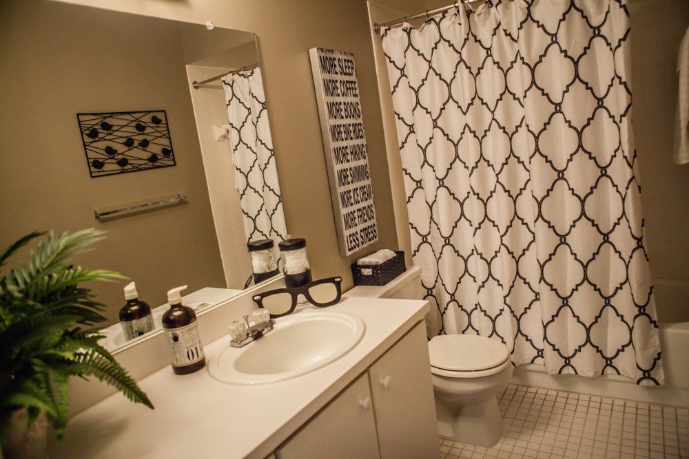 a bathroom with a sink and a toilet and a shower curtain