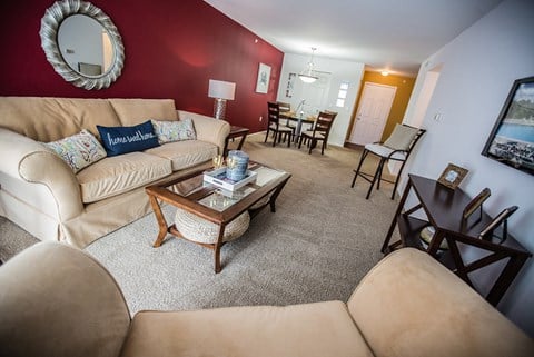A living room with a tan couch and a wooden coffee table.