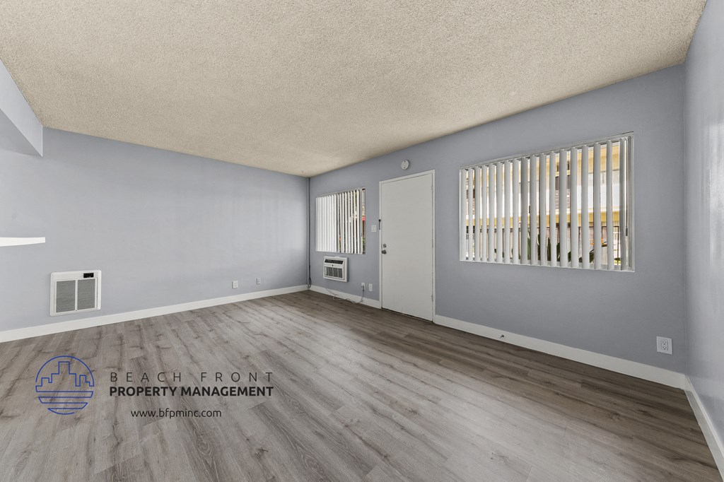 the renovated living room with wood flooring and gray walls