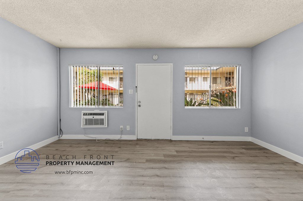 the living room of an apartment with grey walls and a white door