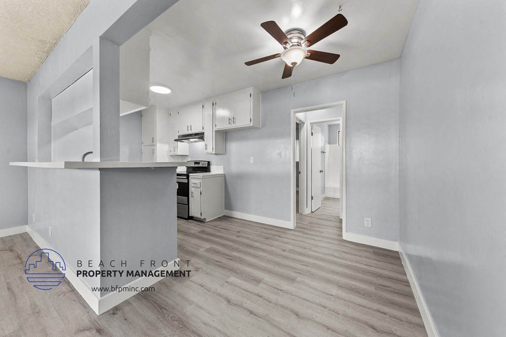 a kitchen with white cabinets and a ceiling fan