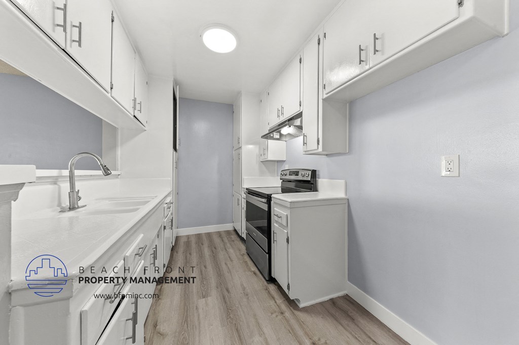 a kitchen with white cabinets and white appliances and white counter tops and a white sink