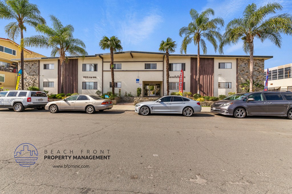 a parking lot in front of a building with palm trees