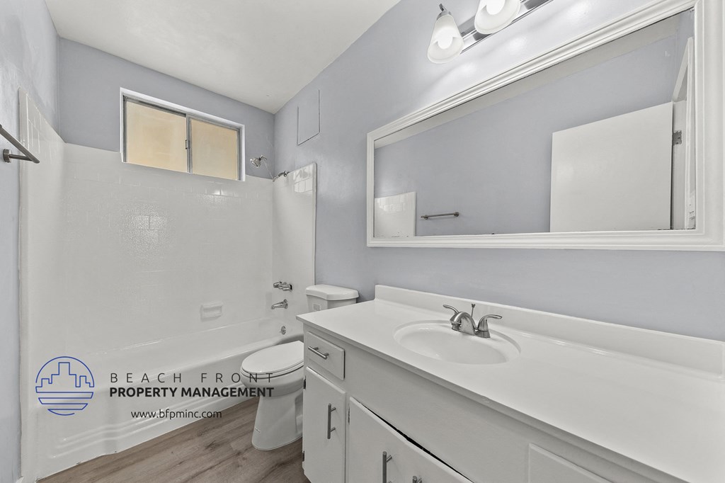 a bathroom with a white sink and a toilet and a mirror