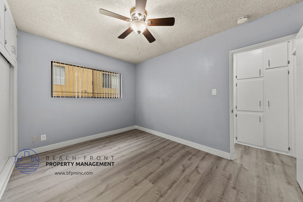 the living room has a ceiling fan and wood flooring