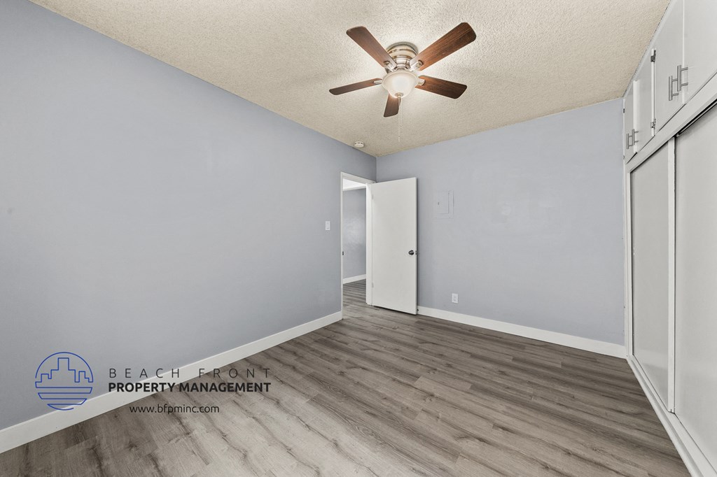 a living room with wood flooring and a ceiling fan