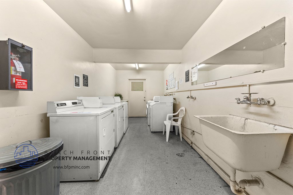 a laundry room with a sink and washing machines and a tub