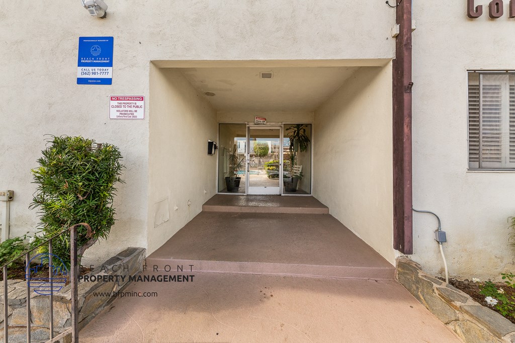 a hallway of an apartment building with a ramp to a door