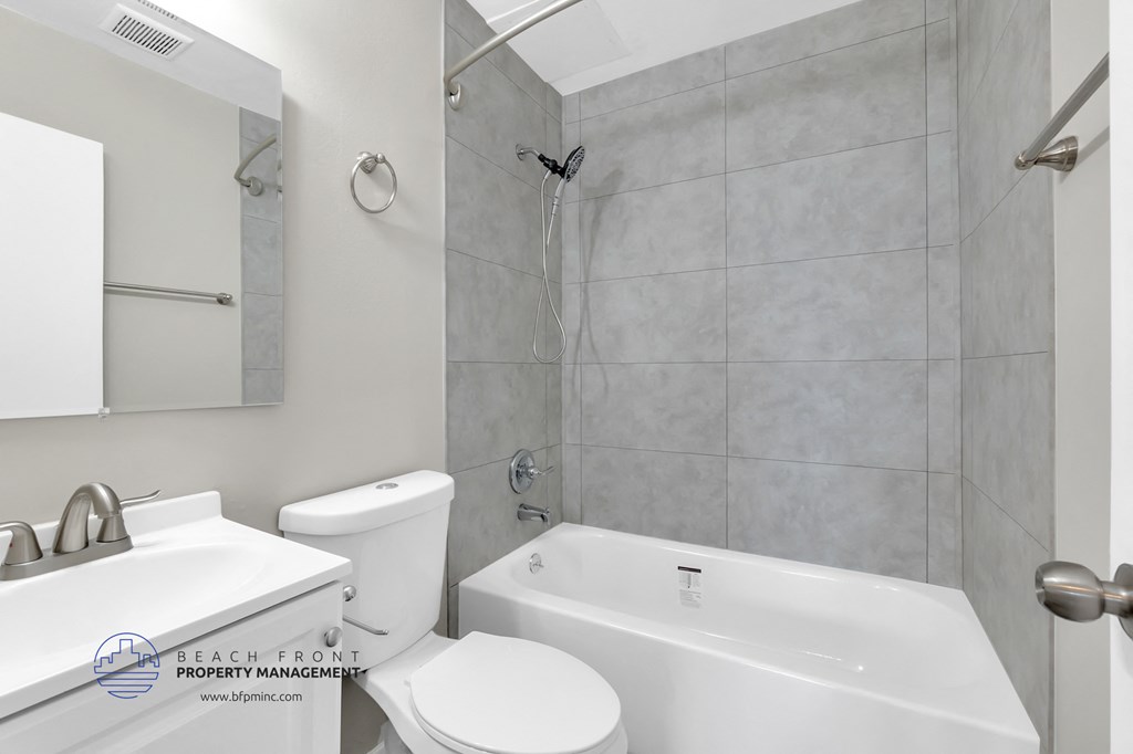 a white bathroom with a white toilet and a tub and a sink