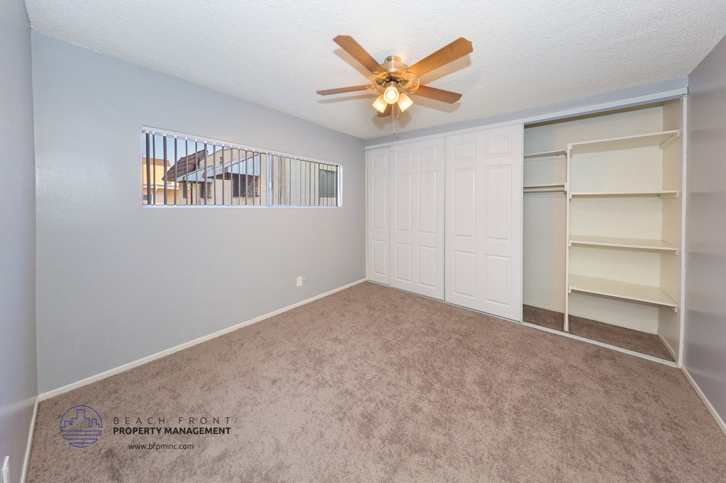 a bedroom with a closet and a ceiling fan