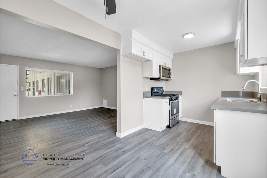 a renovated kitchen with white cabinets and stainless steel appliances