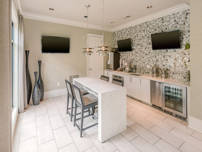 a large white kitchen with a white island and chairs