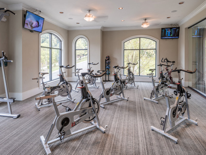 a gym with a lot of exercise equipment and windows