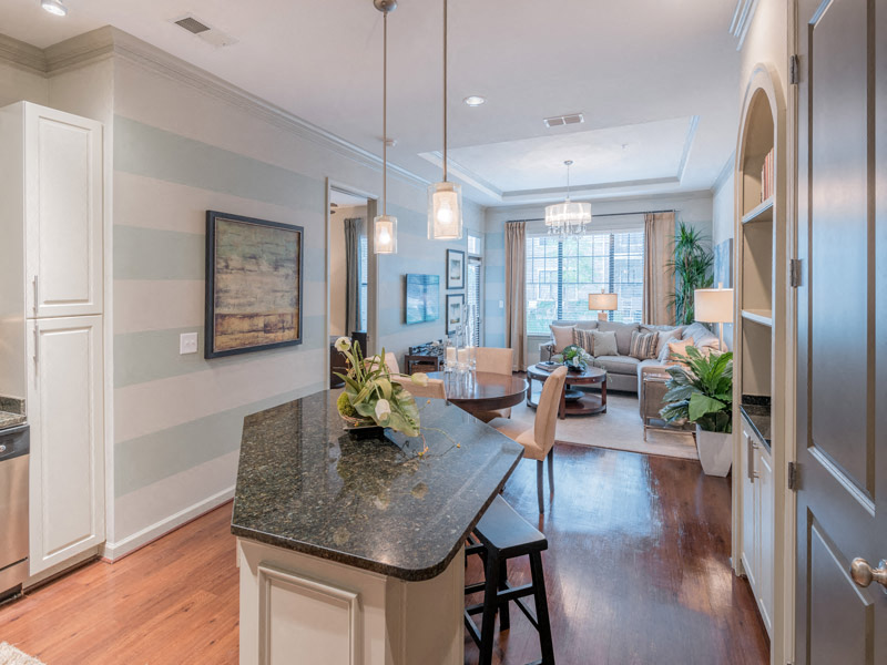 a kitchen with a table and a living room with a couch