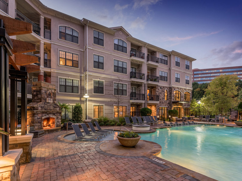 a swimming pool in front of a hotel at night