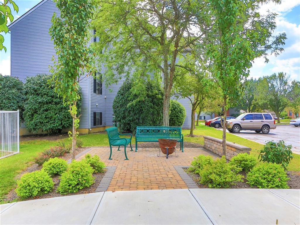 a park bench and a fire pit in front of a house
