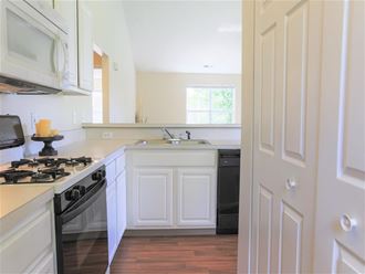 a kitchen with white cabinets and a stove and a sink