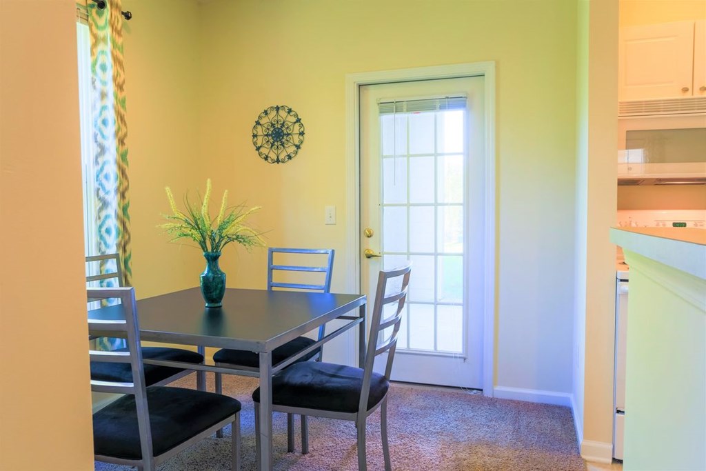 a dining room with a table and chairs and a door