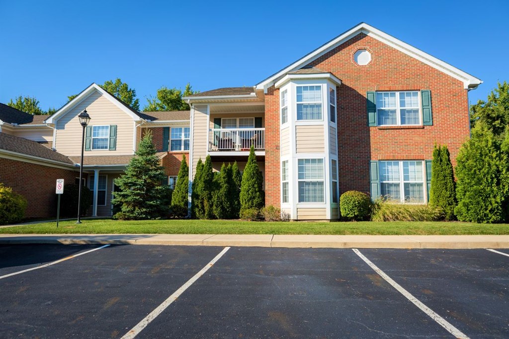 an apartment building with a parking lot in front of it