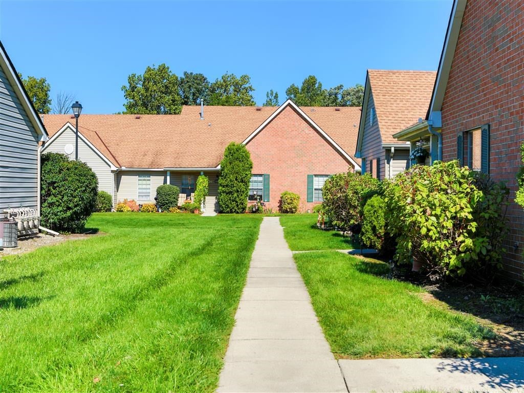 a sidewalk in front of a row of houses