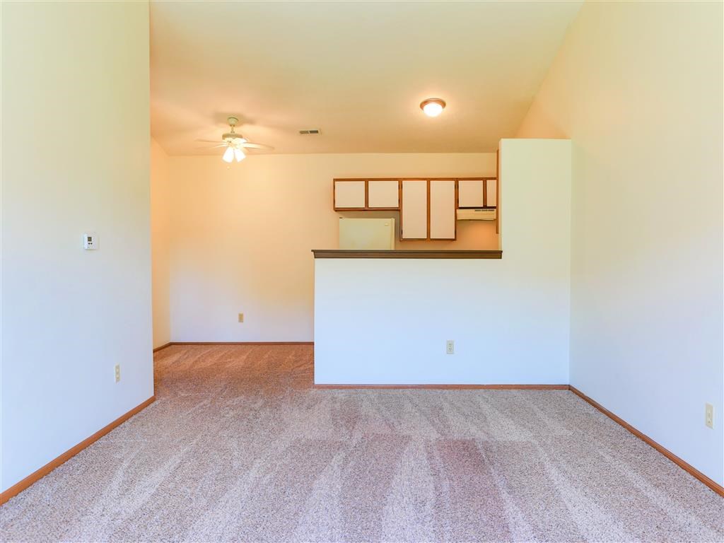 the living room and dining room of an empty apartment