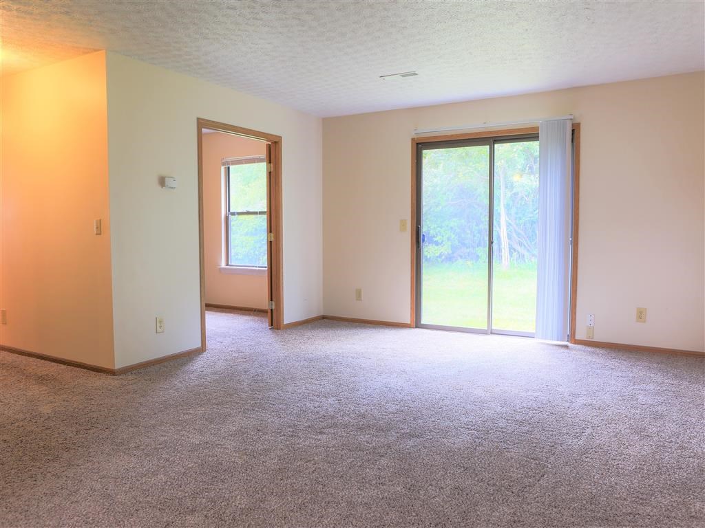 an empty living room with a sliding glass door