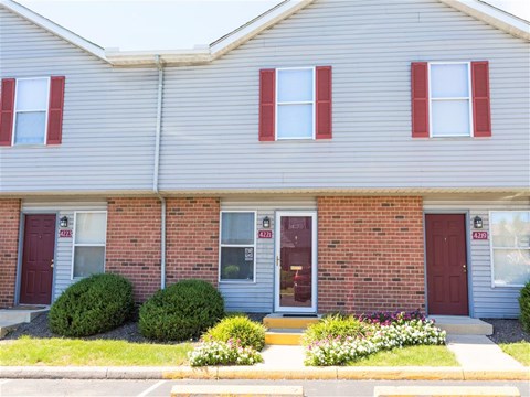 A grey house with red doors and windows.
