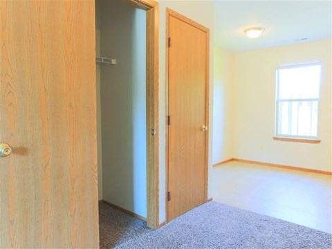 A room with a wooden door and a carpeted floor.