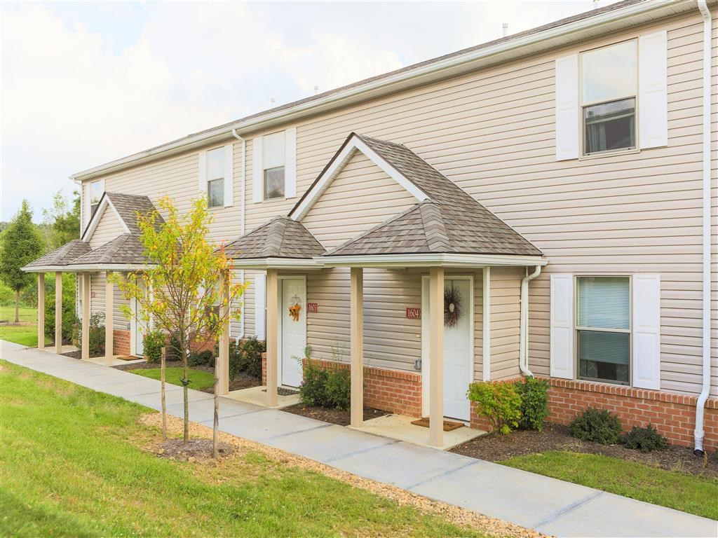 the front of a house with a sidewalk in front of it