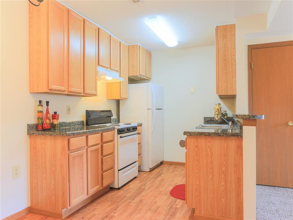 a kitchen with wooden cabinets and a white refrigerator