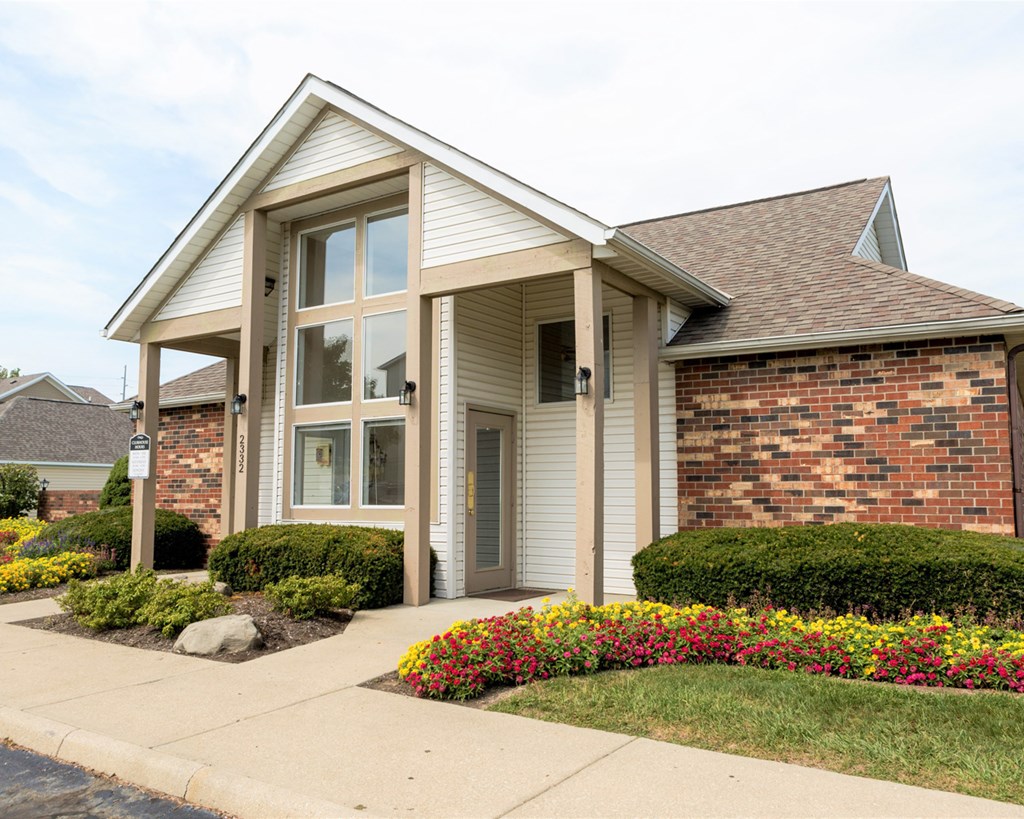 a small brick house with a sidewalk in front of it