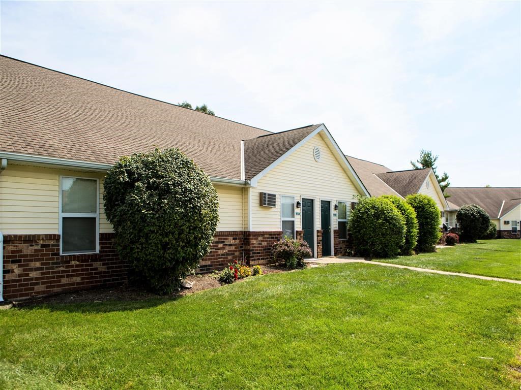 a white house with a green yard and a lawn