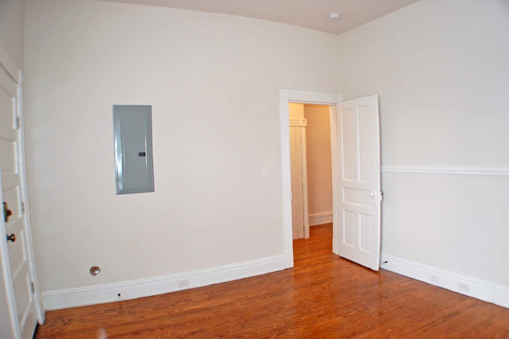 a empty room with a white wall and a door to a closet