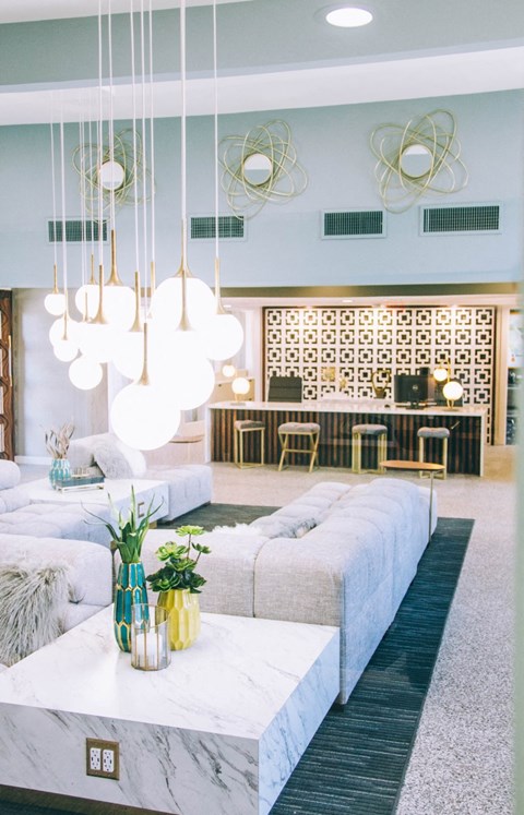 a living room with white couches and a bar