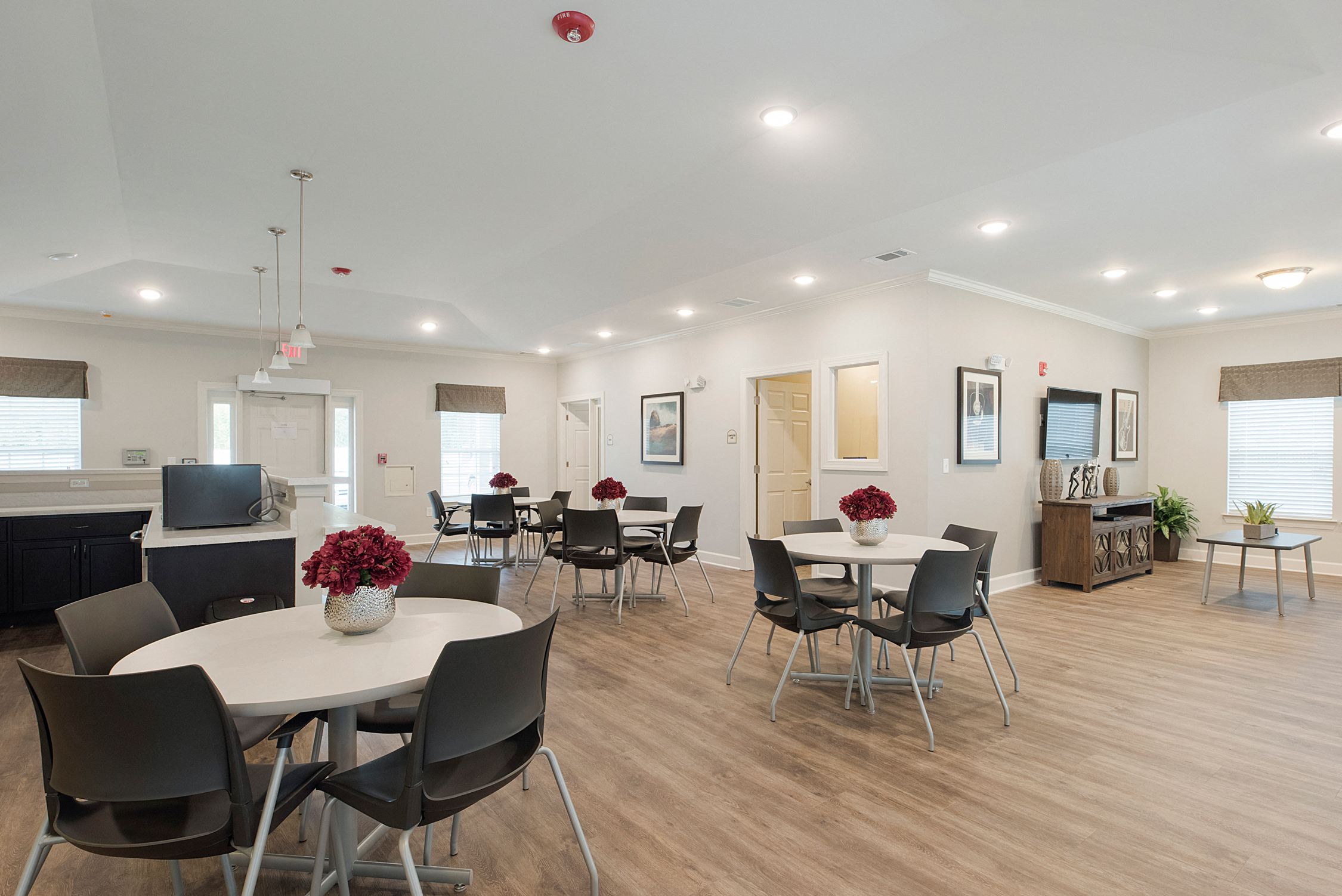 a dining room with tables and chairs and a living room with a tv