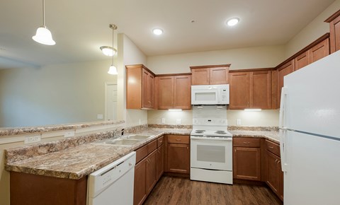 a kitchen with white appliances and granite counter tops