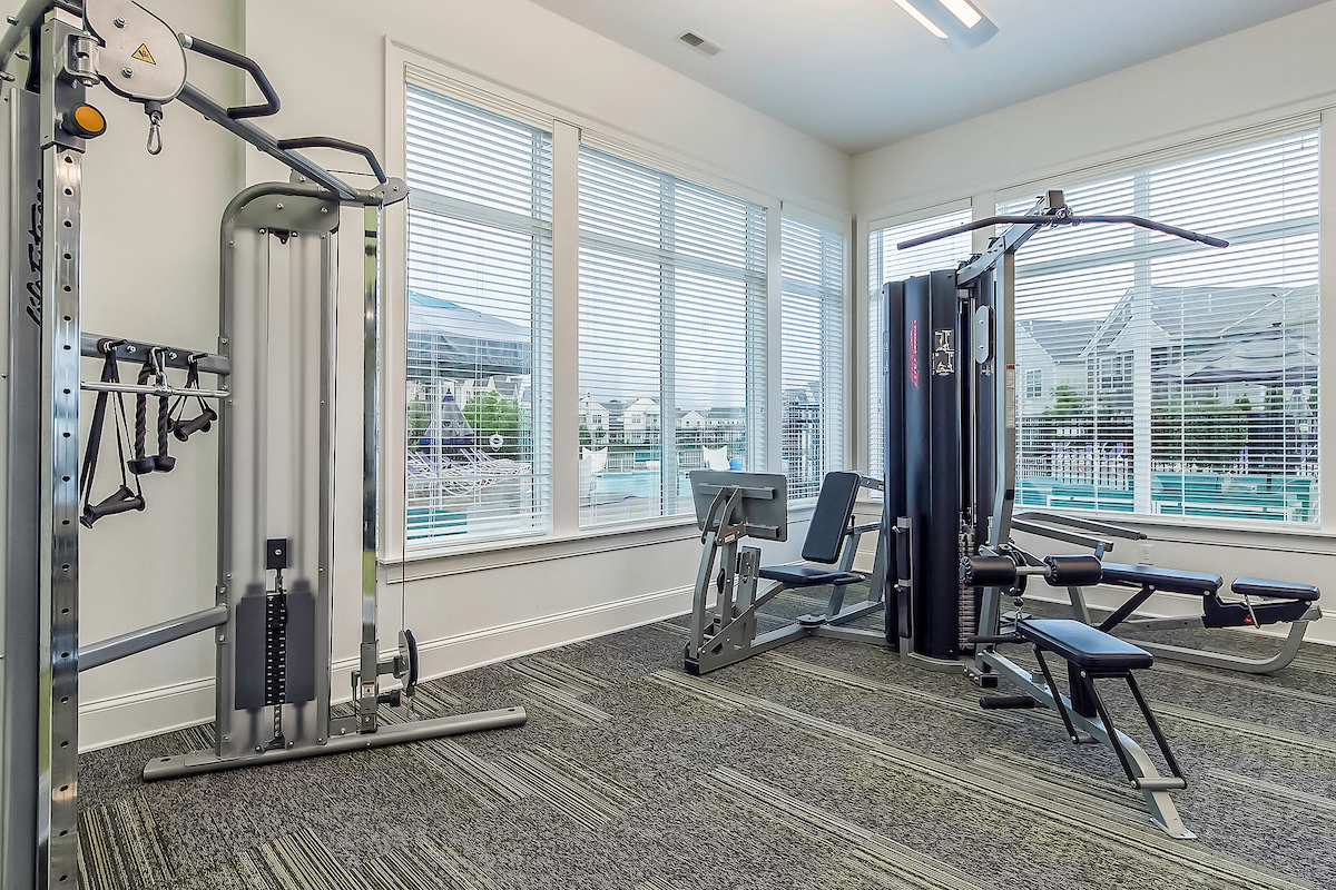 a gym with exercise equipment and windows with a view of the city