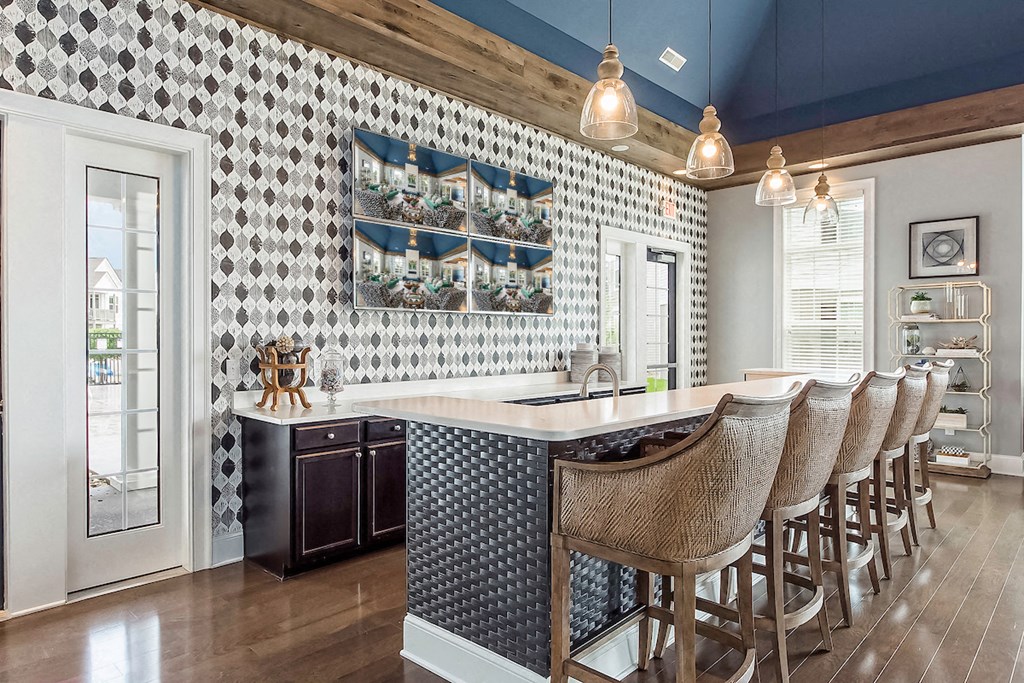 a kitchen with a bar and chairs in a house
