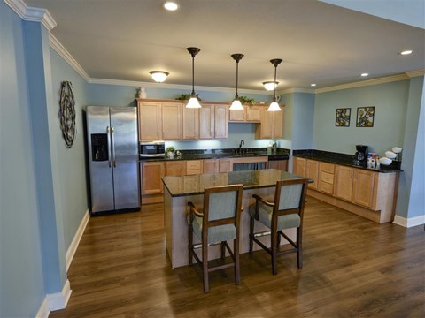 A kitchen with a table and chairs in the middle.