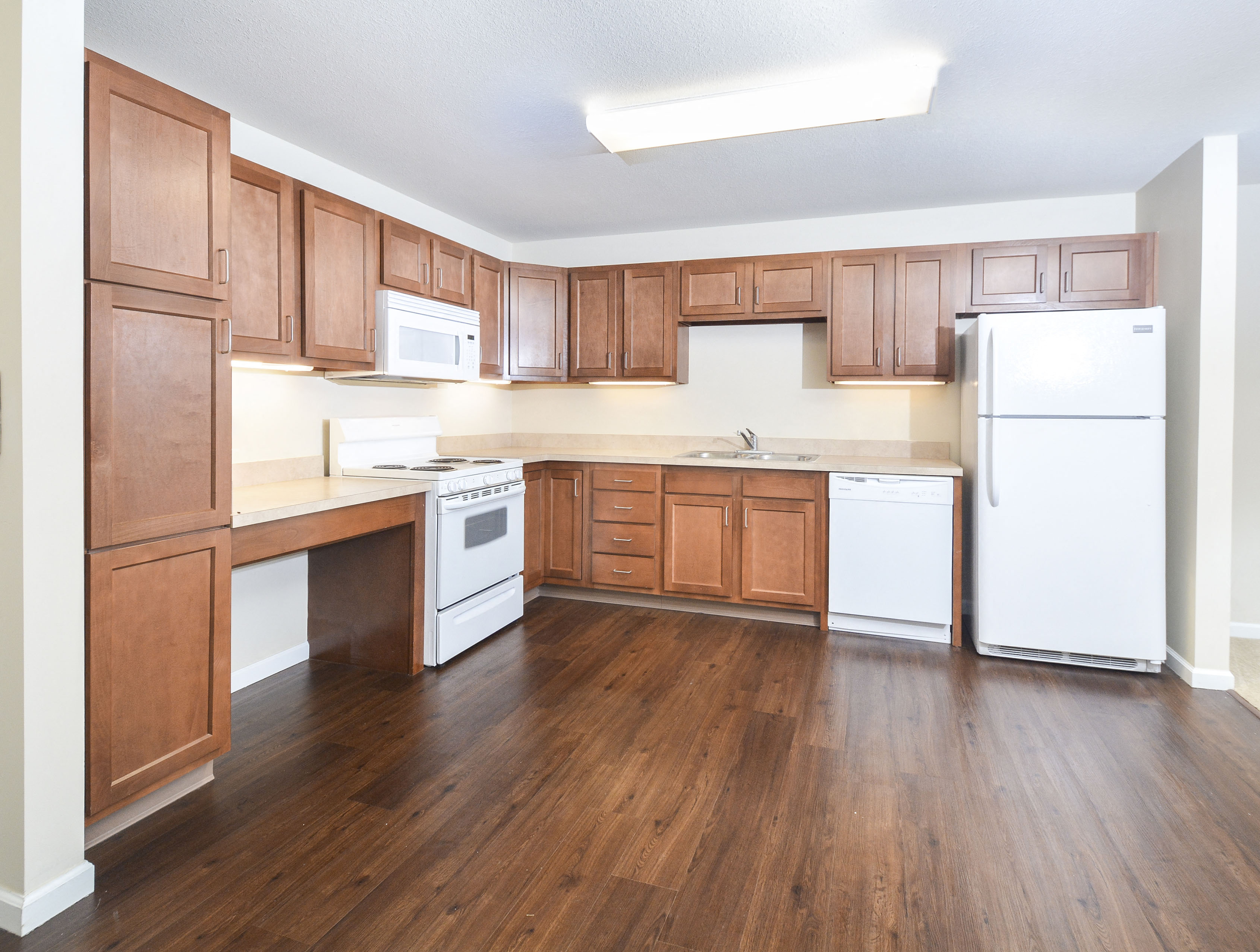 A kitchen with wooden cabinets and white appliances.