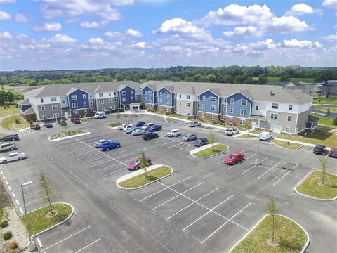 Aerial view of a modern apartment community featuring landscaped grounds, residential buildings, and thoughtfully designed outdoor spaces.
