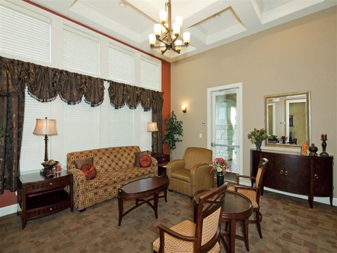 A living room with a couch, chairs, and a table.