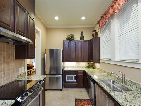 A kitchen with granite countertops and stainless steel appliances.