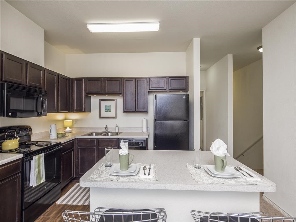 a kitchen with black appliances and a white counter top