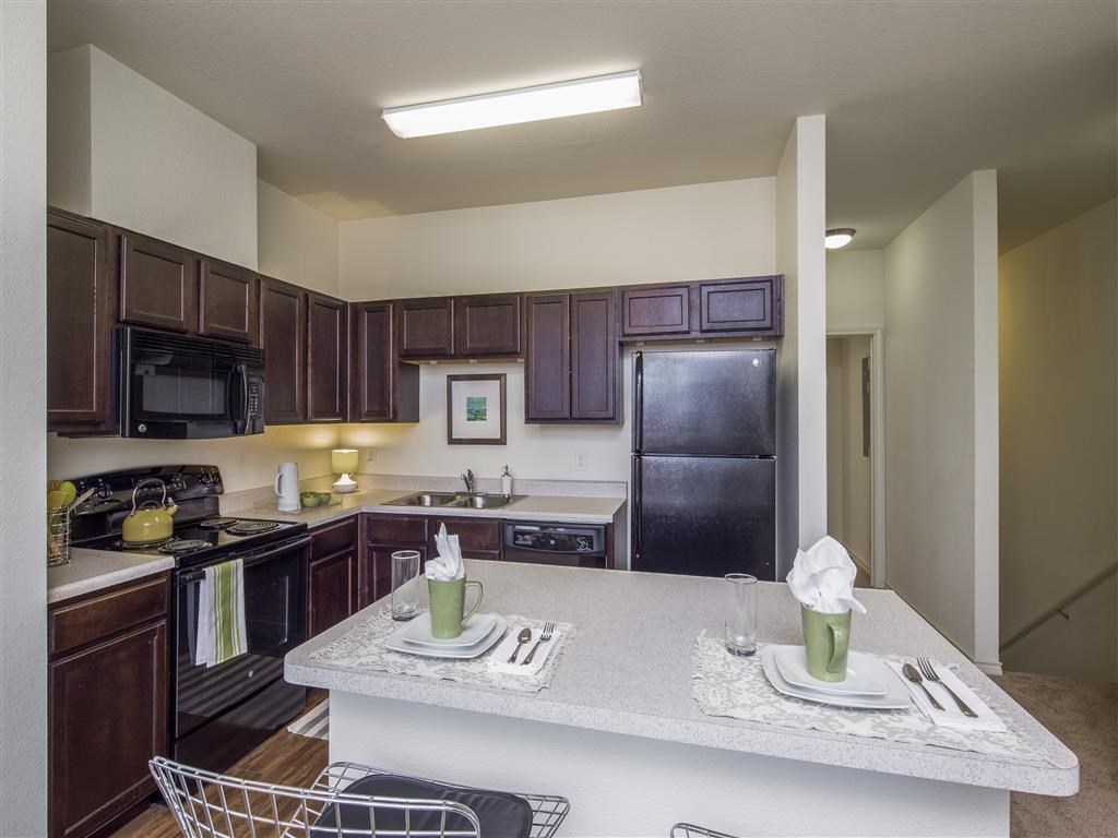 a kitchen with a counter top and a black refrigerator