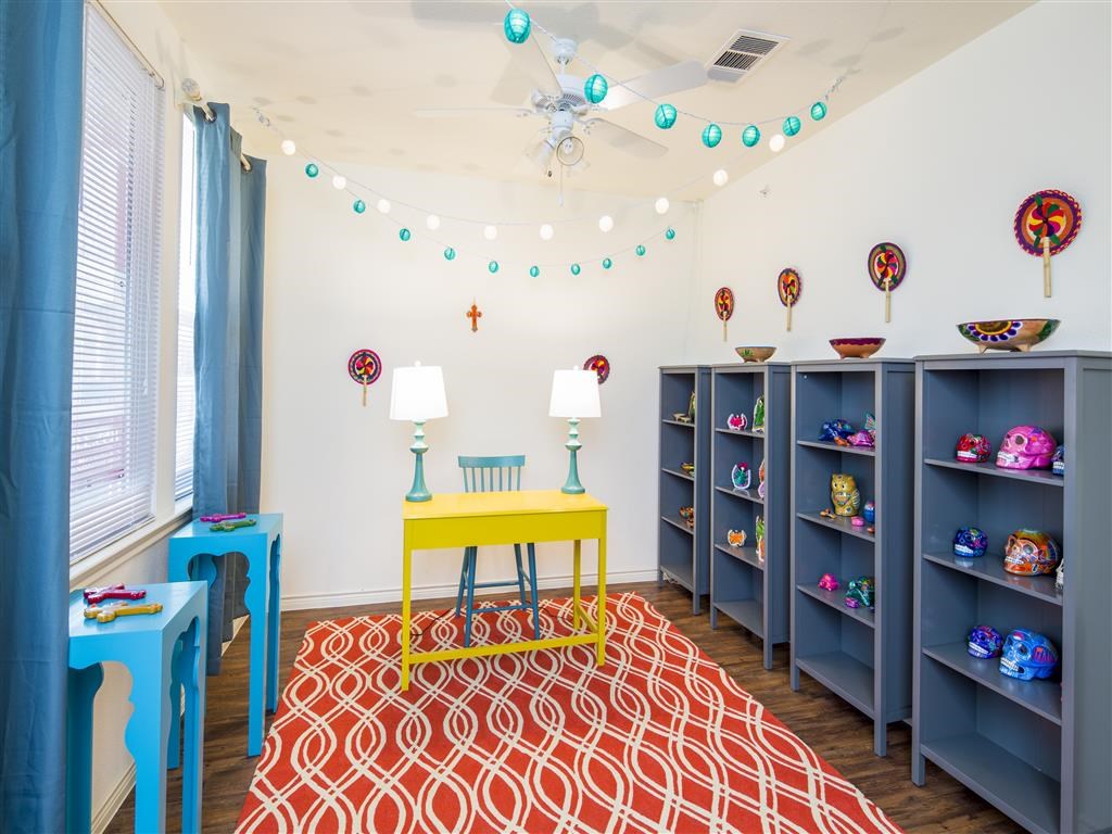 a play room with a yellow table and blue shelves