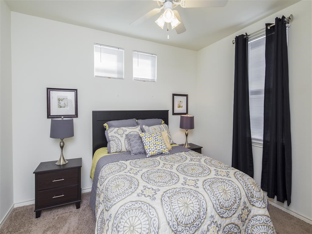 a bedroom with a bed and a ceiling fan