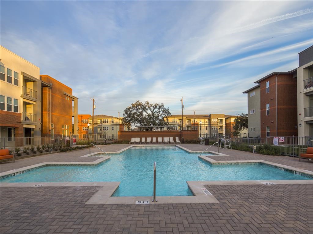a swimming pool with apartments in the background